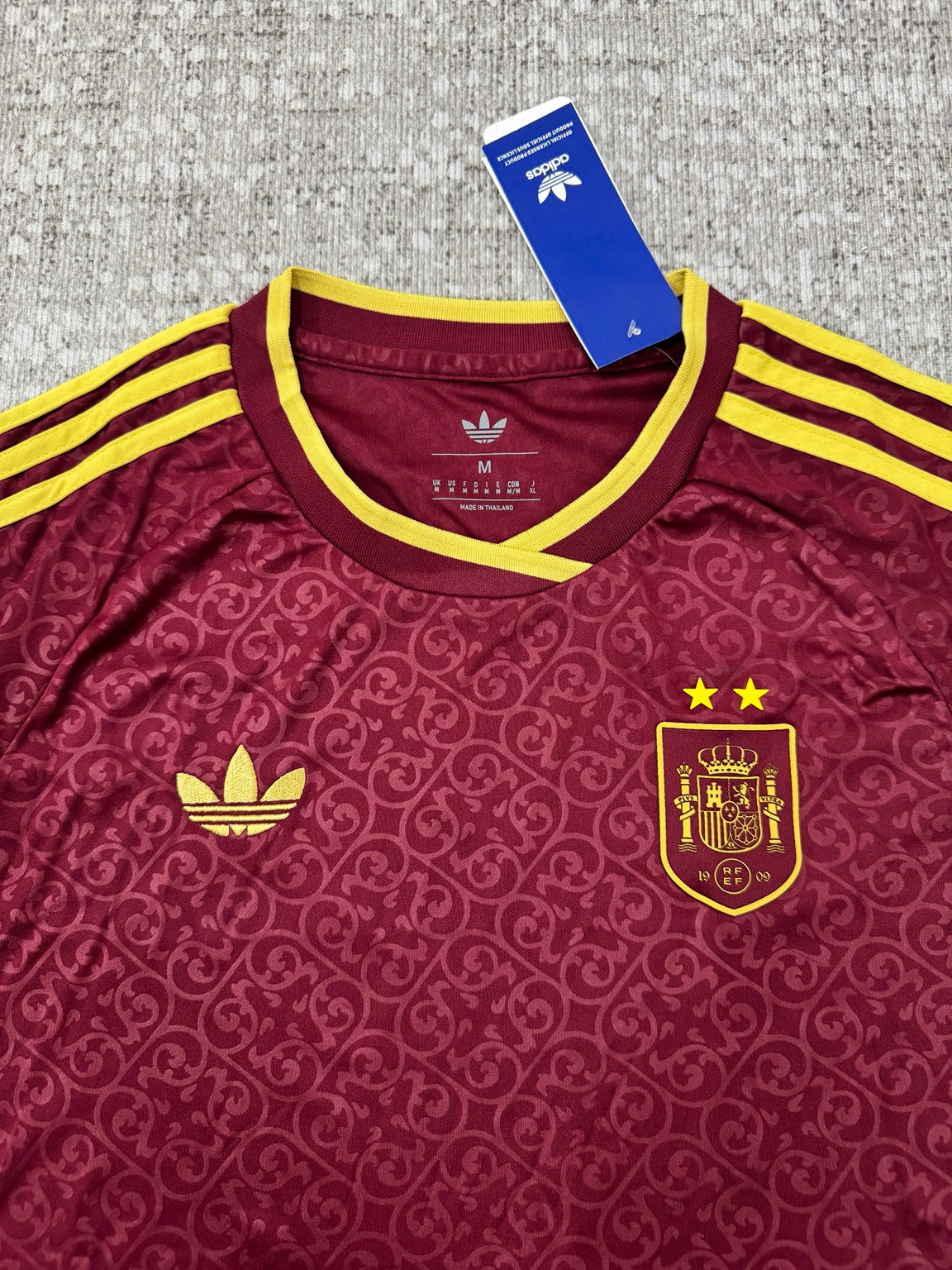 Détail col et écusson maillot Espagne bordeaux et jaune