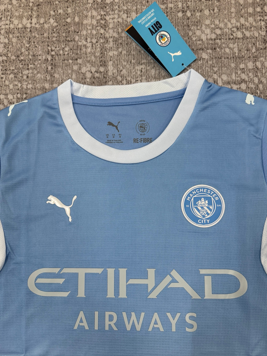 Détail col et écusson maillot Manchester City bleu ciel