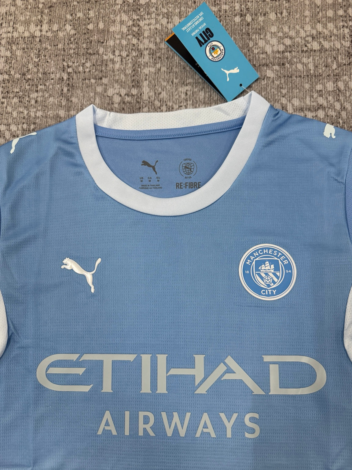 Détail col et écusson maillot Manchester City bleu ciel
