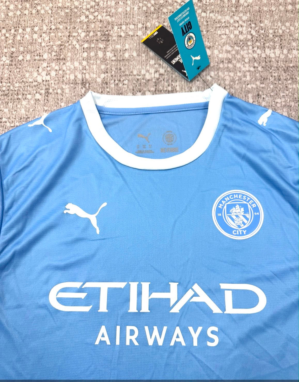 Détail col écusson et sponsor du maillot domicile Manchester City 2026/27 manches longues